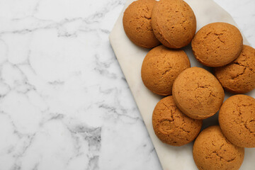 Tray with tasty oatmeal cookies on white marble table, top view. Space for text