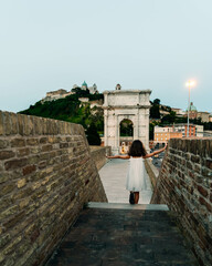 little girl walking on the fortified walls near to Trajan's arch in Ancona