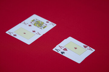 player shows two play card aces on a red table in a casino. gambling