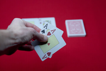 player shows two play card aces on a red table in a casino. gambling