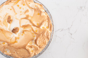 Whole Fresh Lemon Meringue Pie on a Kitchen Counter