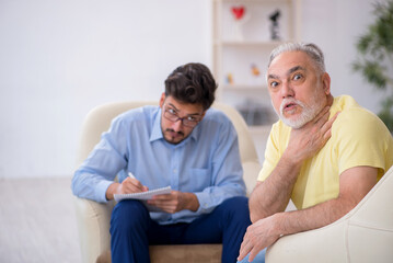 Obraz premium Old man visiting young male psychotherapist
