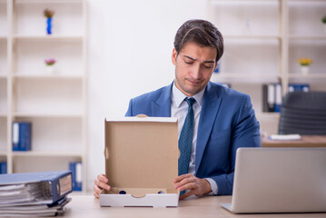 Young male employee eating pizza at workplace