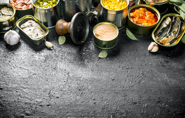 Open tin cans with various canned food.