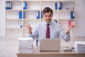 Young male employee and too much work in the office