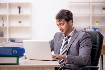 Young male employee unhappy with excessive work in the office