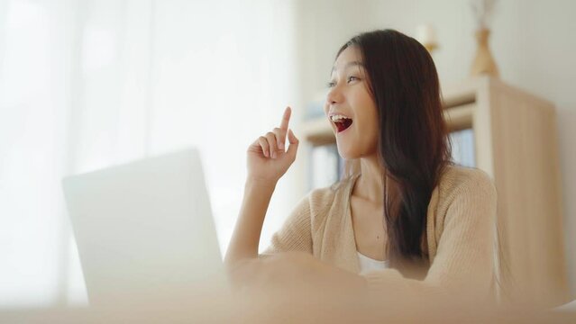 Young asian woman working on computer laptop on desk in living room at home