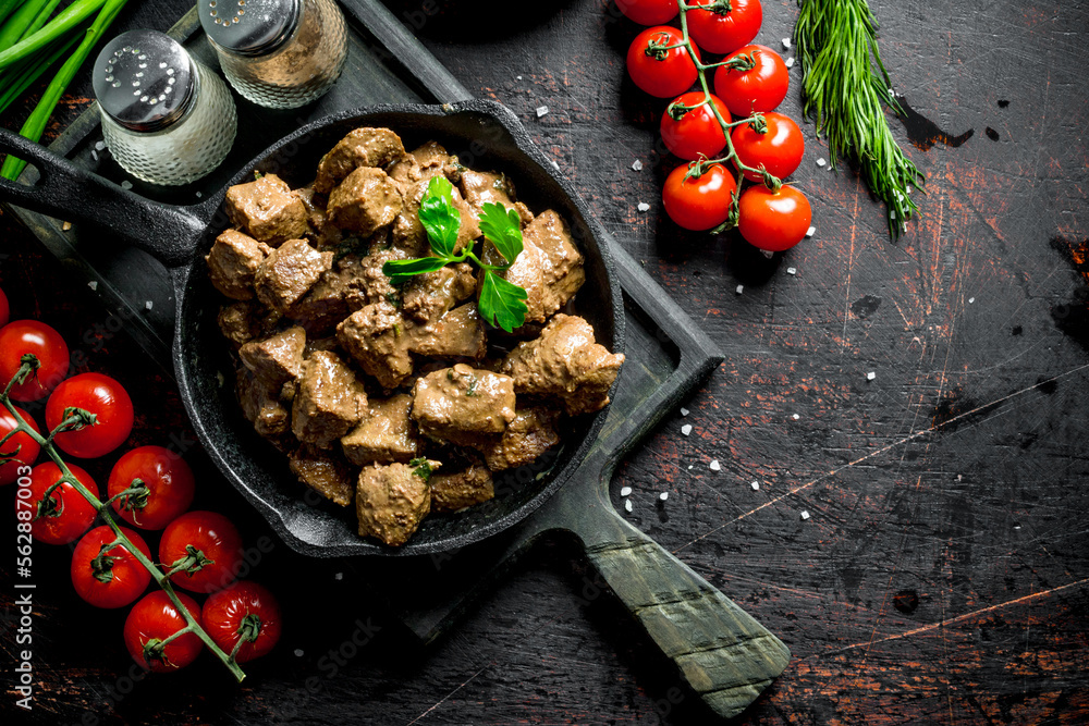 Poster Fried liver with spices and cherry tomatoes on a cutting Board.