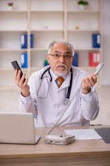 Old male doctor in telemedicine concept