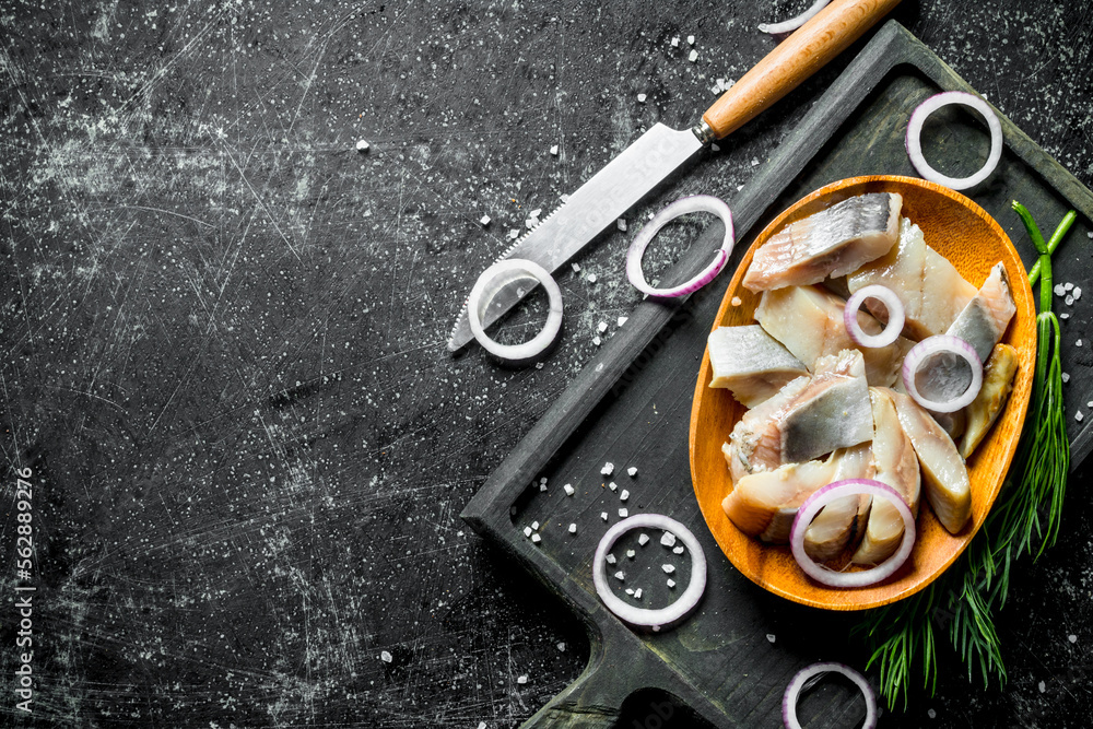 Poster Fillet of salted herring on a cutting Board with a knife, dill and onions.