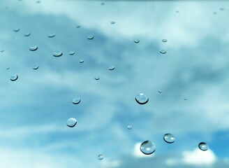 rain drops on glass window reflects the blue sky, copy space background can be used for emotional content 