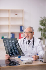 Old male doctor radiologist working in the clinic