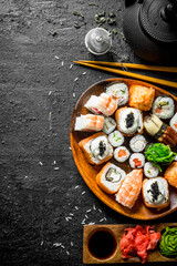 Fresh sushi and rolls with sauces and green tea.