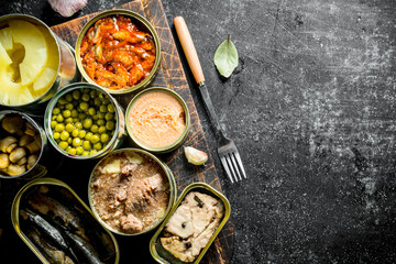 Canned food in various open tin cans on the cutting Board.