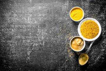 Different types of mustard with a spoon.