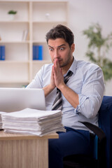 Fototapeta premium Young male employee and too much work in the office