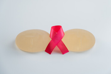 Breast implants and satin ribbon. Breast cancer awareness symbol.