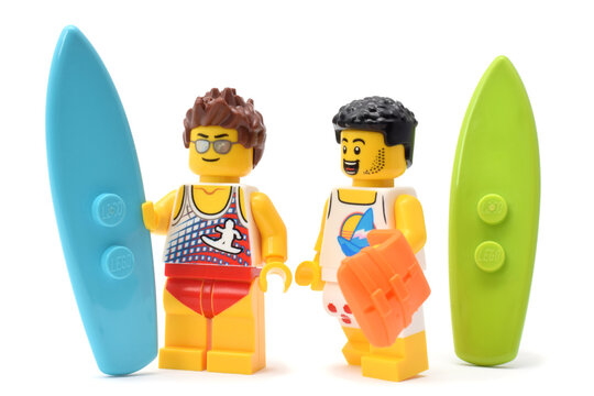 Yellow lego minifigure of surfer with surfboard isolated on white. Editorial illustrative image of  popular children constructor. 