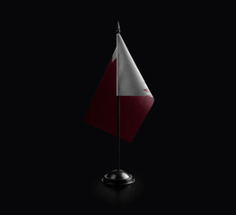 Small national flag of the Qatar on a black background