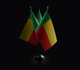 Small national flags of the Benin on a black background