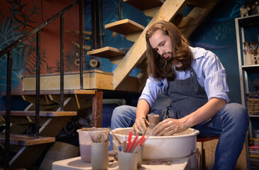 Pottery artist, Young making a piece of clay molding calmly and meticulously In order to produce...