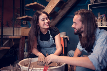 Young couples that enjoy making clay sculptures. Using pottery and assisting one another to create flower vases out of clay
