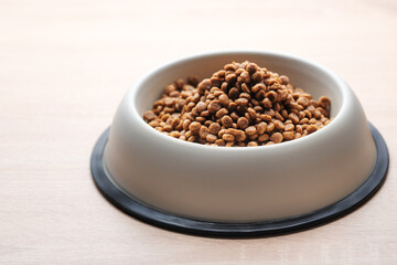 A bowl of dog food on a wooden floor.
