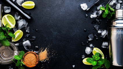 Mojito or caipirinha cocktail and mocktail preparation ingredients: mint, sugar, lime, ice and steel bar tools: shaker, jigger, strainer, muddler on dark background, top view