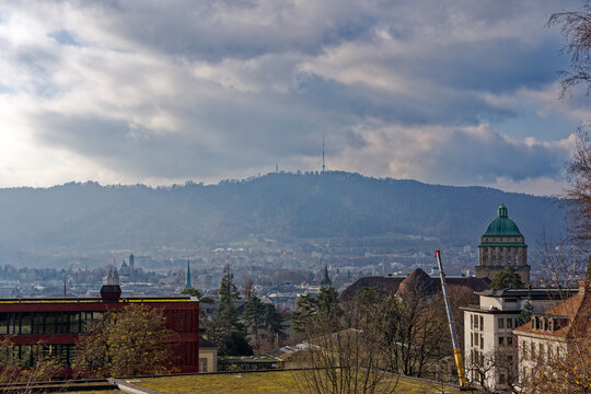 Aerial view of City of Z&uuml;rich with churches and local mountain Uetliberg in the background on a blue cloudy autumn day. Photo taken December 8th, 2022, Zurich, Switzerland.