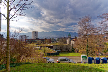 Aerial view of City of Zürich with tower of University and local mountain Uetliberg in the background on a blue cloudy autumn day. Photo taken December 8th, 2022, Zurich, Switzerland.