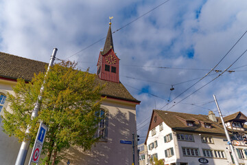 Fototapeta na wymiar Old protestant church with historic house with restautrant at district Fluntern at City of Zürich on a blue cloudy autumn day. Photo taken December 8th, 2022, Zurich, Switzerland.
