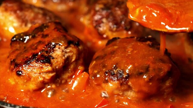 Meatballs with boiling tomato sauce in frying pan 