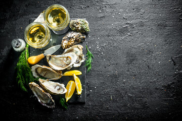 Fresh raw oysters on a stone Board with white wine. - 562917818