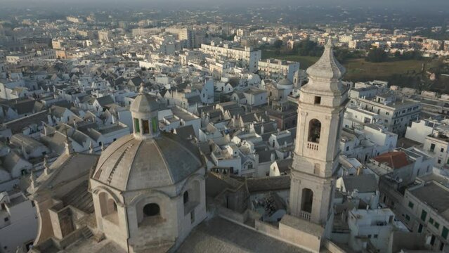 Drone flying over medieval city Locorotondo reveals the dome and tower of the Chiesa Madre di San Giorgio Martire