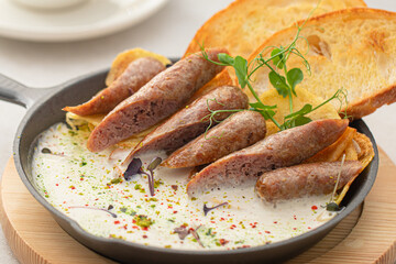 Portion of pan breakfast with sausages and cream sauce