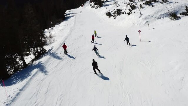 People skiing on a downhill track. Outdoors exercise.