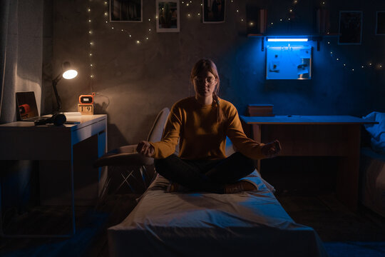 Student Woman Practicing Meditation On The Bed In Dormitory At Night.