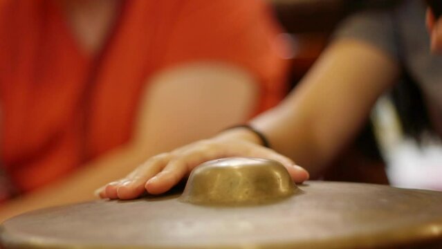 South east Asian Gamelan bonang traditional instrument being tapped rhythmically with mallet, filmed as close up