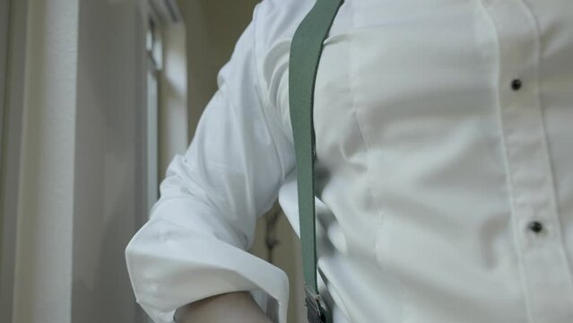 Groom getting ready, putting on suspenders on his wedding day. Shot in 4K 60 FPS. To purchase entire event raw at wholesale price email willneatheryyahoo.com.