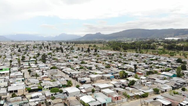 A drone shot of a township in Paarl. This shot showcases houses closes knit together and mild community scattered on the streets.
