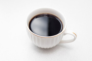 White cup of black coffee on white background