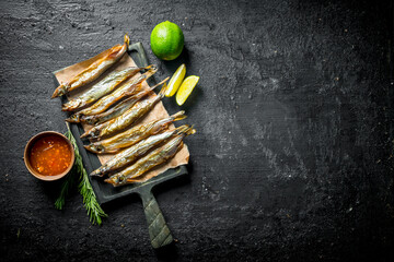 Smoked fish with lime, rosemary and sauce in bowl.