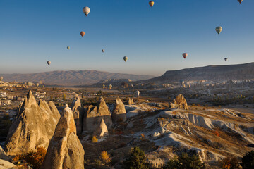 Cappadocia. View of Goreme town with caves and hot air balloons in Cappadocia. Turkey.