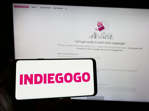 Stuttgart, Germany - 01-14-2023: Person holding smartphone with logo of US crowdfunding company Indiegogo Inc. on screen in front of website. Focus on phone display.