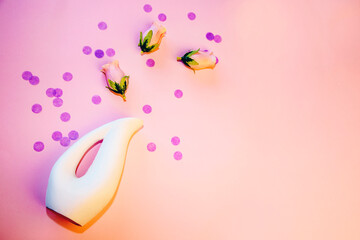 White vase and pink rose petals on a pink background