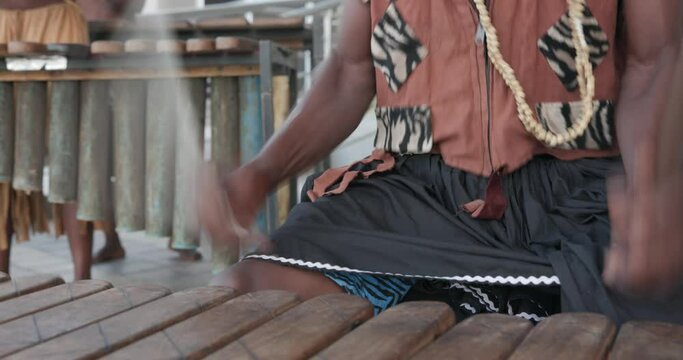 traditional african marimba player in traditional costume playing outdoors