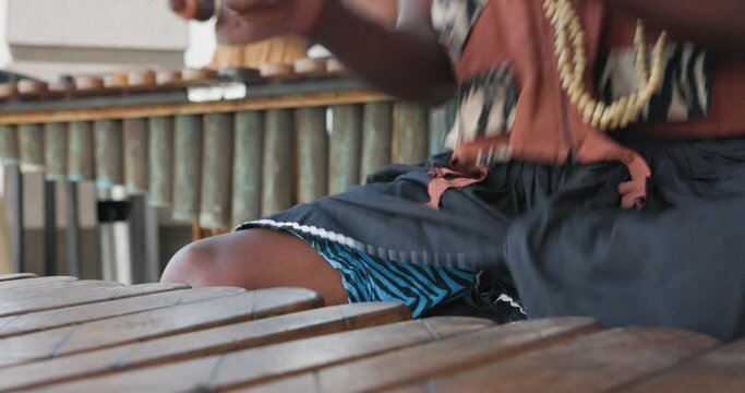 traditional african marimba player in traditional costume playing outdoors