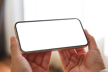 Mockup image of a woman holding mobile phone with blank desktop screen