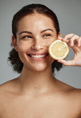 Skincare, face and woman with lemon in studio isolated on a gray background. Fruit, organic...