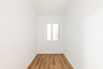 Fototapeta premium Empty room with laminate flooring, newly painted white walls and bright window with frosted glass. Repair and construction concept.